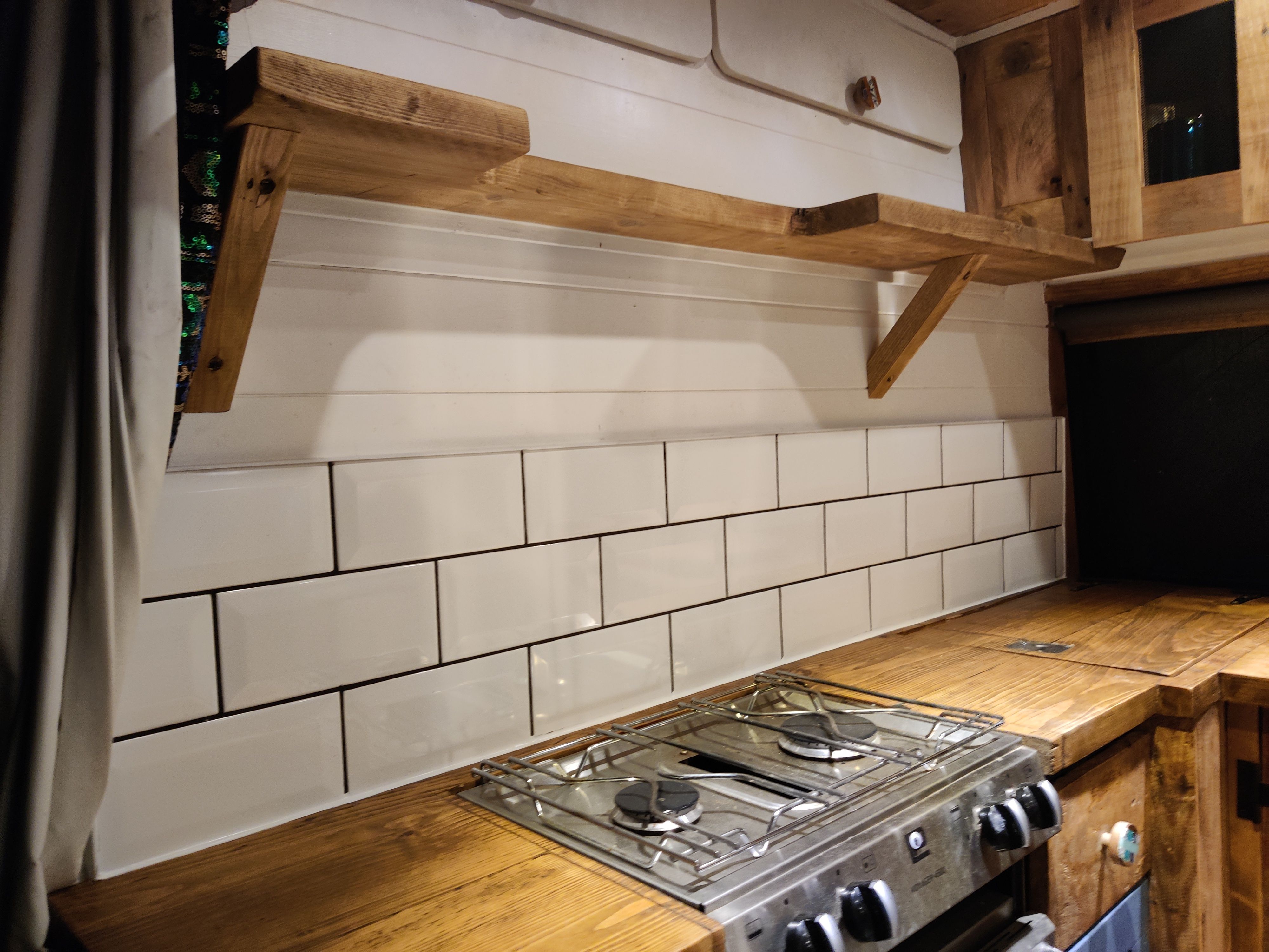 Hand-built campervan interior with warm timber lighting