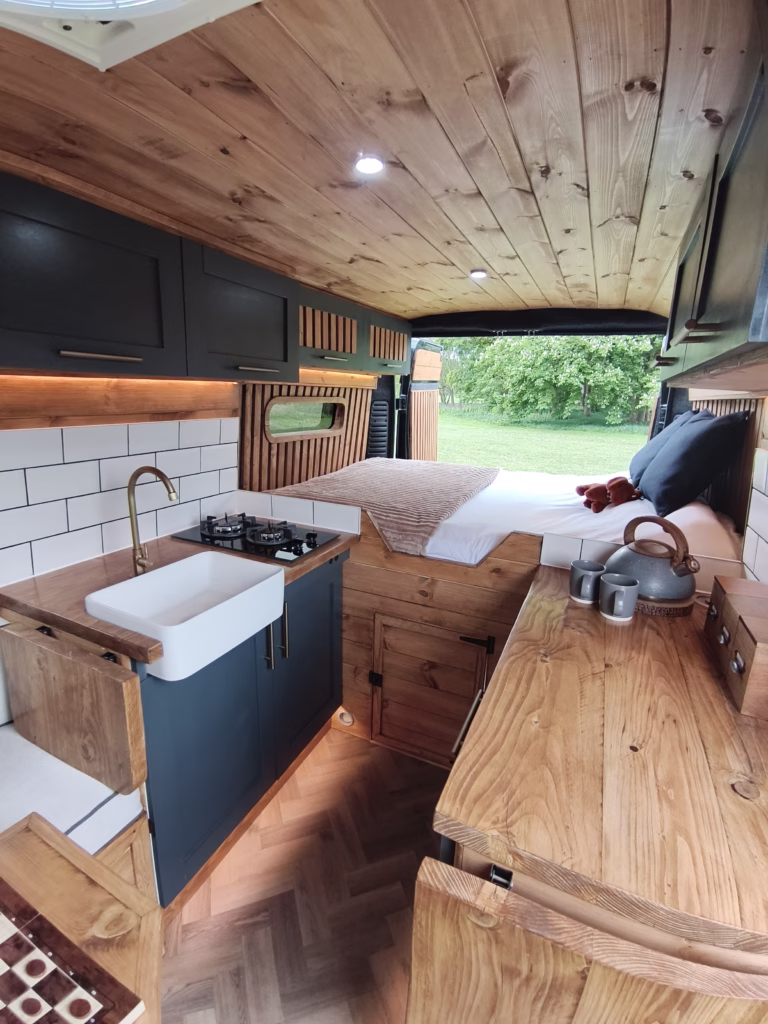 Custom campervan kitchen with Belfast sink and tiled splashback